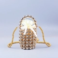 Detail der goldenen Perltasche mit cremefarbenem Satin-Innenfutter und Perlen-Handgriff - Gold