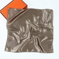Close-up of glossy coffee satin square scarf with draped texture and premium finish - Khaki