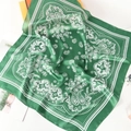 Detail of a green silk square scarf with white paisley pattern and smooth satin texture - Green
