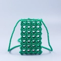 Dettaglio della trama di perline verdi fatte a mano su una piccola borsa a tracolla porta cellulare - Verde