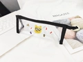 Détail d'une trousse en PVC transparent avec motif d'ours jaune et bordure noire zippée - Ours à lunettes