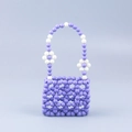 Détail d'un sac à main perlé à la main avec treillis lilas et petites fleurs blanches - Violet