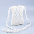 Dettaglio della borsa per cellulare in perline fatta a mano con trama geometrica traforata - Bianco