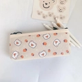 Close-up of cream canvas pencil case featuring cute bear and strawberry prints - Multiple Strawberries