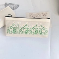 Detail of cream canvas pencil case with embroidered small white flowers and green grass pattern - White Daisy