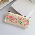 Dettaglio dell'astuccio in tela con motivi floreali rosa freschi su una scrivania bianca - Stile Cosmos Rosa