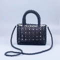 Dettaglio di borsa fatta a mano in perline nere con trama intrecciata e fodera in tessuto bianco - Nero