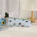 Detailweergave van een gebloemde pennenzak met groene rits op een minimalistisch bureau - Blauw-wit Geruit Bloemen / Smaragdgroen