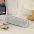 Astuccio in peluche blu con trapuntatura a nuvola e zip rosa sulla scrivania - Blu