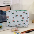 Dettaglio della borsa da trucco trapuntata a fiori con griglia blu e cerniera verde - Verde (Grande)