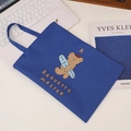 Royal blue A4 canvas document bag with cute cartoon bear and zip closure shown on a desk - Bear With Baguette Print / Navy Blue
