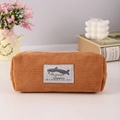 Détail d'une trousse en velours côtelé caramel avec écusson requin et zip blanc - Marron