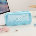 Close-up van lichtblauwe gaas etui met schattige geborduurde ogen op een bureau - Blauw