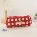 Detail of red waffle plush pencil case featuring a textured lamb wool fabric and woven label - Red Check
