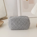 Macro shot of grey teddy plush stationery bag with quilted diamond pattern and metal zipper - Gray