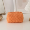 Macro detail of plush orange faux fur stationery bag with classic quilted diamond pattern - Orange