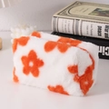 Nahaufnahme des Plüsch-Mäppchens mit orange-weißem Blumenmuster und weicher Fellstruktur - Orangefarbene Blume