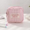 Primo piano della mini trousse trapuntata rosa con cerniera su una scrivania con accessori - Rosa
