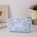 Detailed macro view of light blue floral quilted texture and sweet girl woven label - Flower Blue