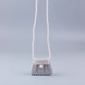 Detailed view of handmade pearl woven crossbody bag with large pearl clasp and long strap - White