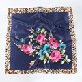 Detailed macro view of the leopard print border and pink roses on a blue satin scarf - Navy Blue