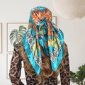 90cm lake blue silk scarf with orange floral prints and retro vine border on model - Camellia Green