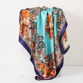 Detail of teal paisley silk scarf with orange patterns draped on display stand - 90cm / Classic Paisley Green