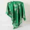 Close-up of green paisley print silk scarf draped over a minimalist white geometry stand - 90x90cm / Green