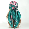 Elegant green satin headscarf with pink floral pattern shown on a mannequin head - Green Plum Blossom
