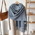 Detail of blue and brown plaid cashmere-like scarf with fringe on a wooden hanger - Haze Blue