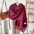 Detail of red and blue plaid scarf with fringes draped over a white coat in home setting - Wine Red
