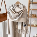 Classic British plaid cashmere-like scarf with tassels on a wooden hanger display - Off-white