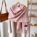 Detail of pink plaid cashmere-feel scarf with fringes styled on a wooden hanger - Pink