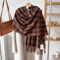 Detail of tan plaid cashmere-feel scarf with tassels and label on a wooden hanger - Brown