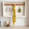 Chic mustard yellow knitted wool scarf with long fringe hanging on white wooden ledge - Yellow