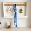 Light blue slim knitted wool scarf with minimal brand tag hanging on a wooden hook - Oxygen Blue