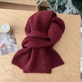 Detail view of burgundy knit scarf featuring elegant bow embroidery and soft wool texture - Burgundy