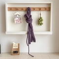 Purple knitted wool scarf with thick texture and brand label hanging on a wooden hook - Grape Purple