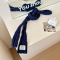 Navy blue cable knit skinny scarf with a minimalist white woven label and soft texture - Navy Blue
