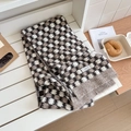 Detail of wool blend knit scarf featuring a classic beige and brown checkerboard pattern - Khaki Plaid
