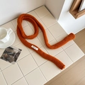 Soft orange 100% wool knit skinny scarf styled in a cozy minimalist home setting - Orange