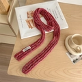 Winter colorful speckled knit scarf in magenta placed on a warm wooden table - Confetti Red