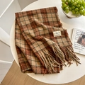 Retro plaid cashmere-feel scarf with tassels and brand label on a minimalist white desk - Brown