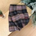 Rosa und blau karierter Strickschal mit Fransen und Markenetikett auf Holzgrund - Grauviolett