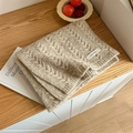 Classic beige knit scarf with cable pattern and textile label on wooden surface - Beige