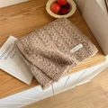 Brown chunky knit scarf with white woven label on natural wood textured background - Khaki