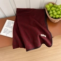 Écharpe épaisse à carreaux pied-de-poule rouge et noir avec étiquette de marque sur table - Rouge