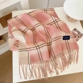 Pink and beige checkered plaid scarf with soft fringe tassels on a minimalist white desk - Pink