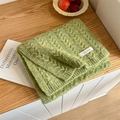 Thick cable knit scarf in green and yellow blend with a white textile label - Fruit Green