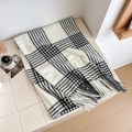 Classic black and white checkered scarf with fringe tassels shown in a cozy setting - Over 175cm / White